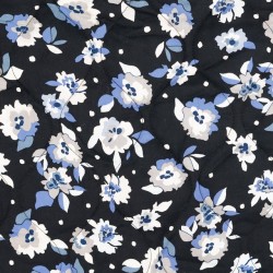 Quiltet stof i sort med blomster i blå, grå, hvid