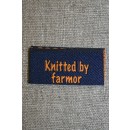 Blå/orange mærke "Knitted by farmor"